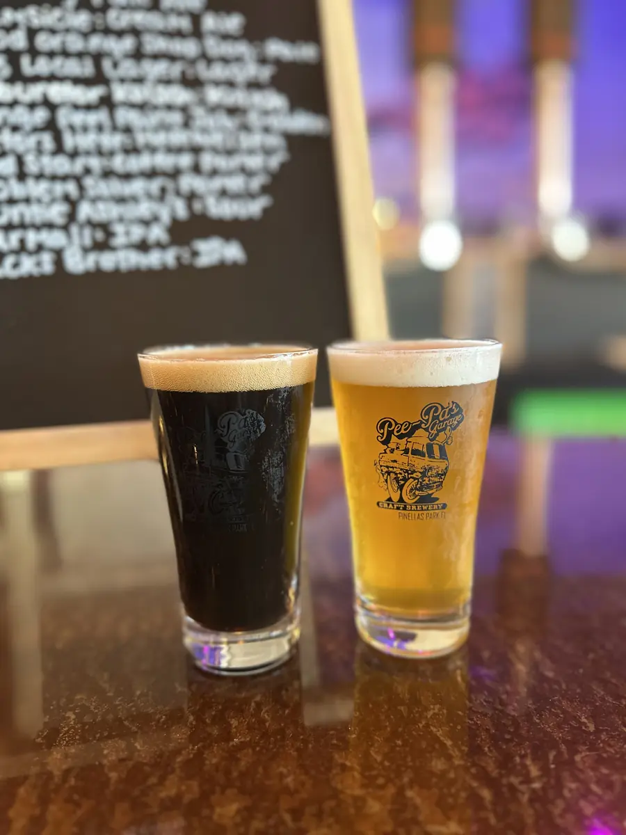 Two Pee-Pa's Garage pints in front of the chalkboard tap list